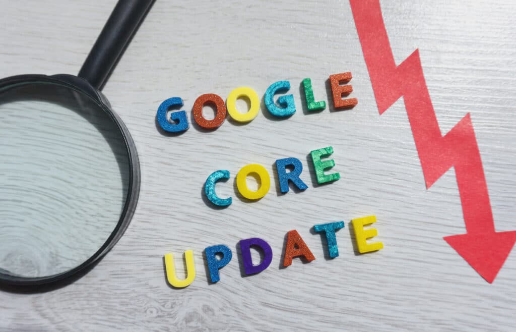 A magnifying glass next to colorful letters, showcasing the impact of a recent Google Algorithm Update on a website.